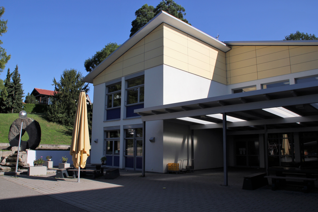 Caféteria des Goethe Gymnasiums von außen. Im Mittelgrund ein gelber Sonnenschirm